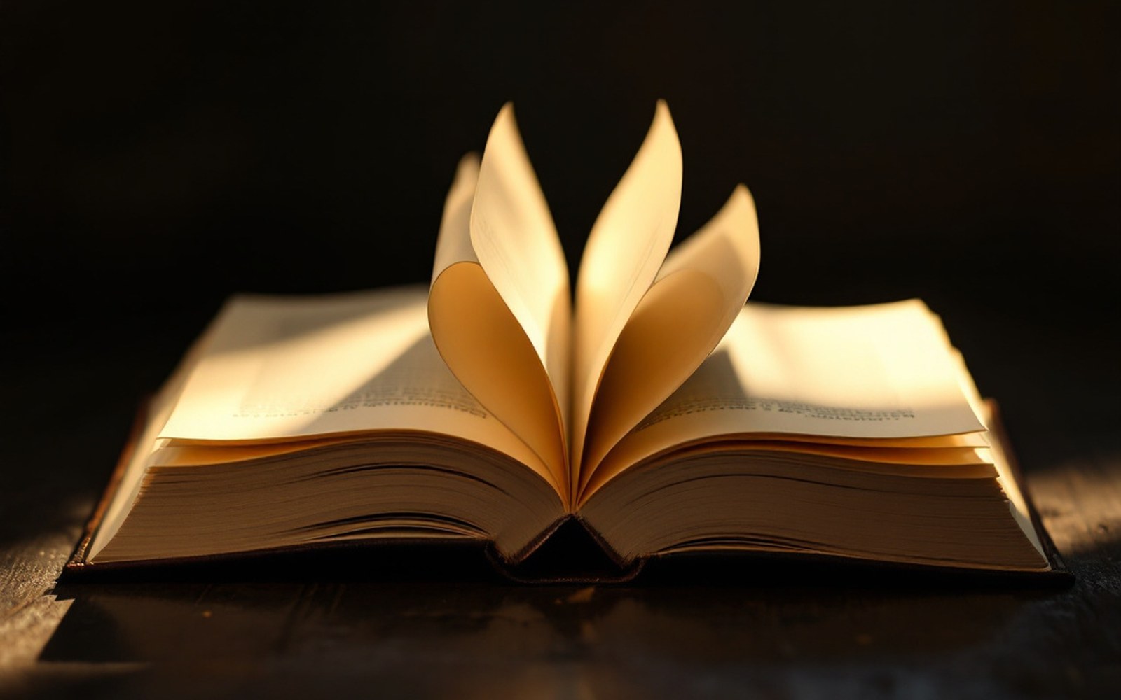The uncut edges of a book's final pages still joined, held by a hand, raking light